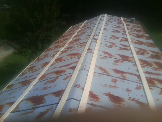 Rusted metal roof panels with new wood purlins before replacement — Storm Damage Roof Repair in Clarence by Roofing Brothers